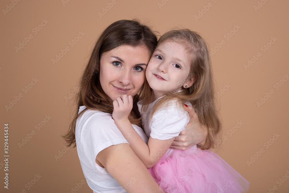 nother and her charming little daughter are hugging and smiling nother and her charming little daughter are hugging and smiling