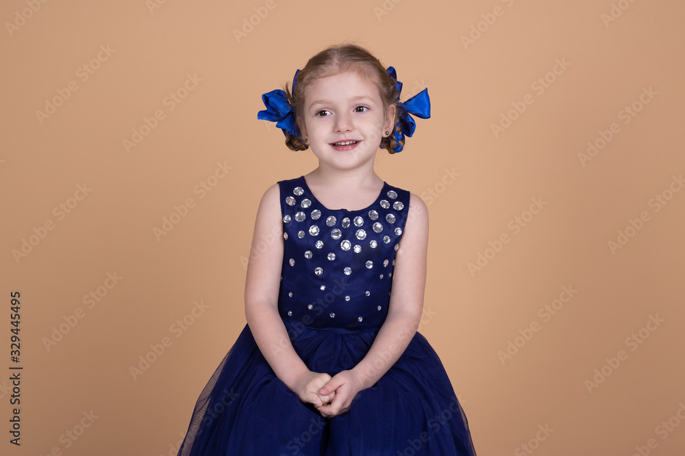 happy little girl in blue dress isolated on neutral background happy little girl in blue dress isolated on neutral background