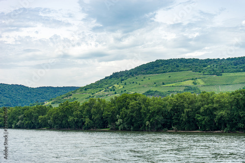 Germany, Rhine Romantic Cruise, a body of water with a mountain in the background © SkandaRamana