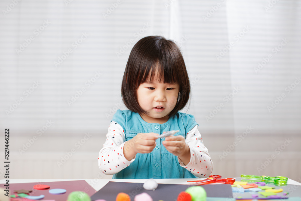 toddler girl learn making Origami at home against white background toddler girl learn making Origami at home against white background