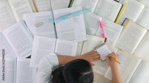 Funny timelapse of woman studying at desk with many books, top view