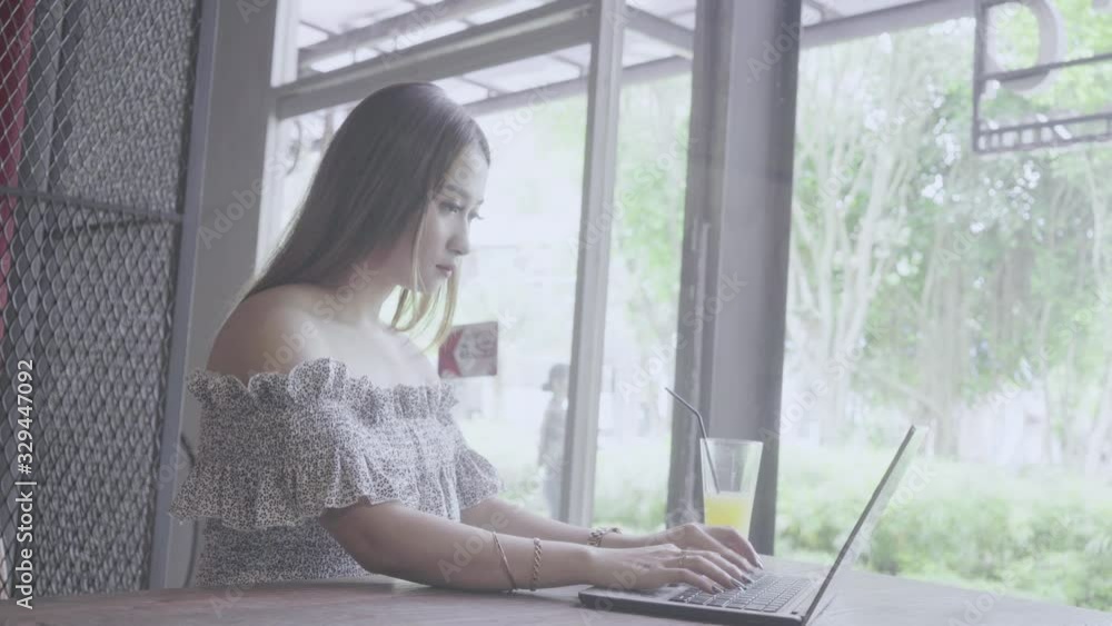 Pretty young woman using laptop computer while calling waitress in the cafe. Shot in 4k resolution Pretty young woman using laptop computer while calling waitress in the cafe. Shot in 4k resolution