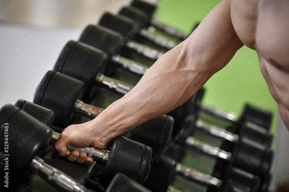 Man working out strength exercises in a fitness gym Man working out strength exercises in a fitness gym