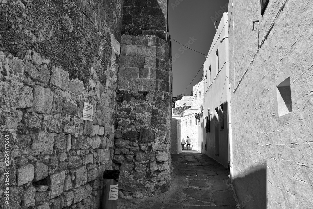 landscape from the historic city of lindos on the greek island of rhodes with white old tenement houses landscape from the historic city of lindos on the greek island of rhodes with white old tenement houses