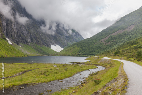 Mountain road with snow remnants in the middle of summer in Norway, selective focus