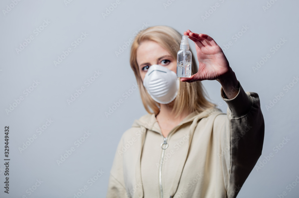 Blonde woman in protective mask with disinfection gel Blonde woman in protective mask with disinfection gel
