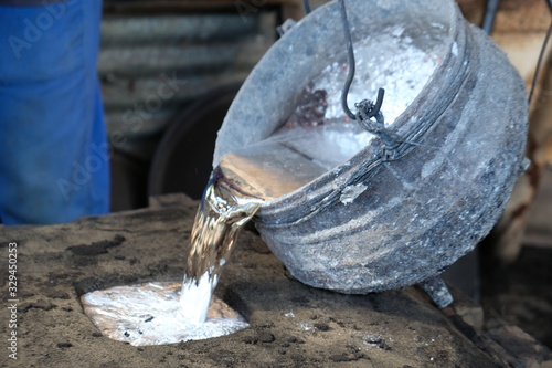 Molten metal being cast into a mold for making artisanal pots