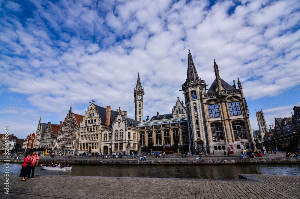 Ghent, Belgium, August 2019. Breathtaking cityscape: from the St. Michael bridge along the Graslei canal. One of the most beautiful postcards in the city. On the left a couple stopped to admire.