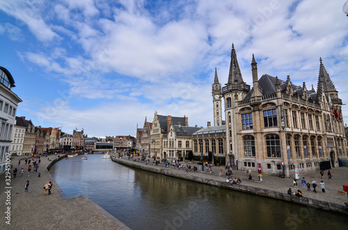 Ghent, Belgium, August 2019. Breathtaking cityscape: from the St. Michael's bridge to the street along the Graslei canal. One of the most beautiful postcards in the city. People stop to watch.