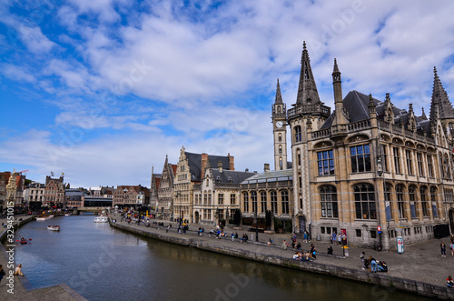 Ghent, Belgium, August 2019. Breathtaking cityscape: from the St. Michael's bridge to the street along the Graslei canal. One of the most beautiful postcards in the city. People stop to watch.