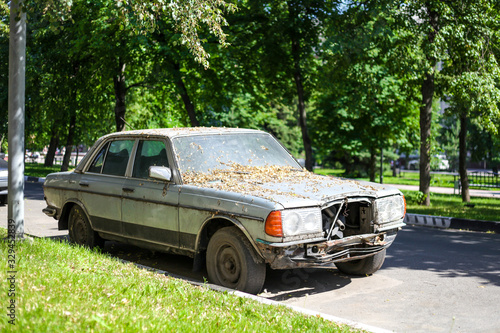 An old, broken car is standing on the sidelines. © skelington
