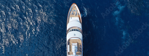 Aerial drone ultra wide top down photo of luxury yacht with wooden deck docked in Aegean island with deep blue sea, Greece © aerial-drone