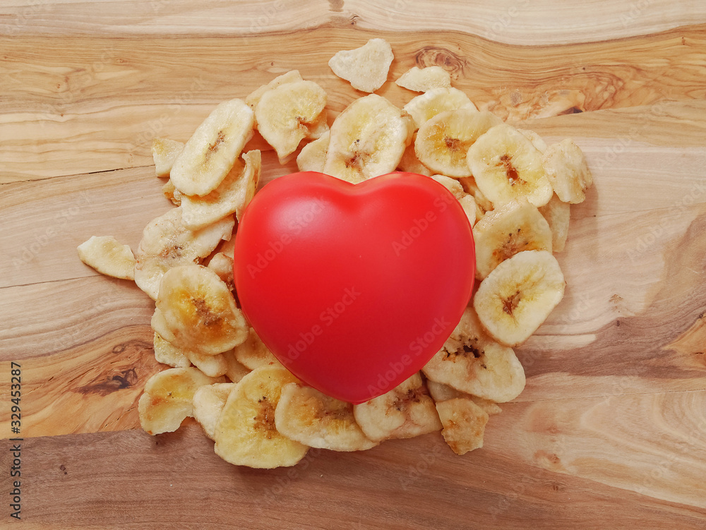 Red heart on a pile of dried organic bananas, Concept healthy food