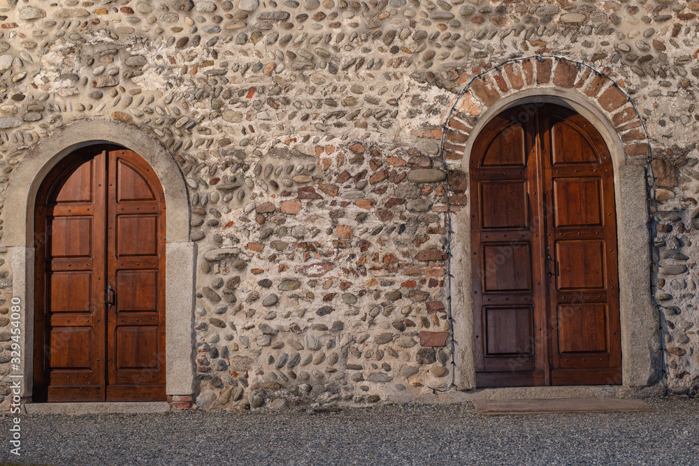 old wooden doors in stone wall, Romanesque style old wooden doors in stone wall, Romanesque style