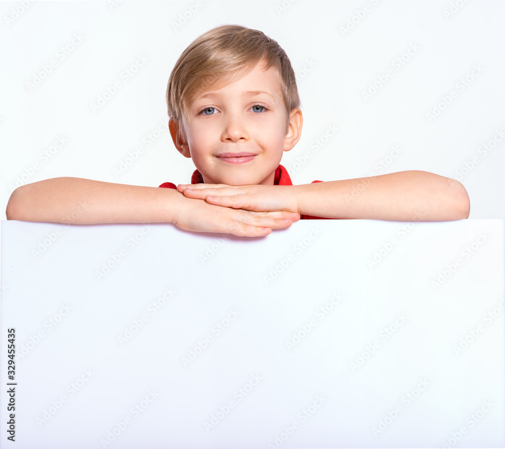 Happy kid look outs from the blank billboard. Portrait of a happy boy with a white banner. Photo of a cheerful 8 years old kid looking at camera above an white paper banner, isolated on white Happy kid look outs from the blank billboard. Portrait of a happy boy with a white banner. Photo of a cheerful 8 years old kid looking at camera above an white paper banner, isolated on white