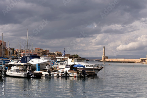 View of moored boats, yachts and ancient lighthouse (island Crete, Greece)