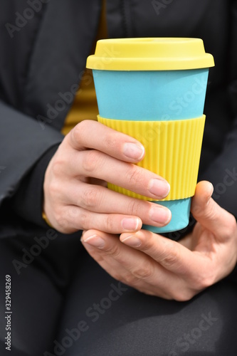 Female hands holding reusable coffee mug. Take your coffee to-go.
