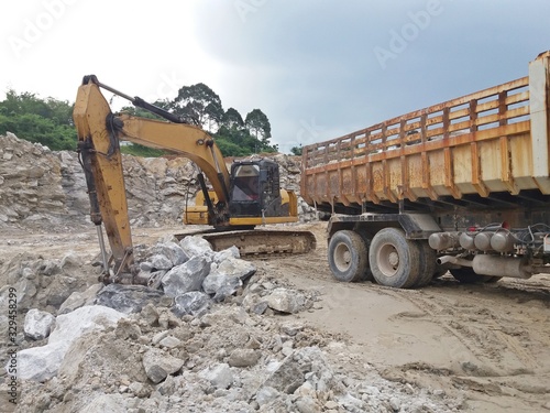 Backhoe digging for gypsum ore And loaded at the ten-wheeled truck at the mine
