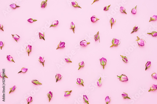 Dried pink roses for tea on pink background. Top view.