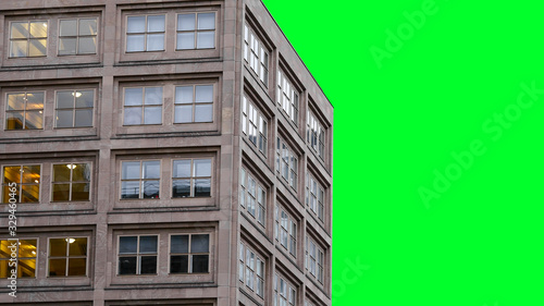 Isolated real building on green screen. Modern residential building with square windows. In some windows the lights are on, in others they are not. European symmetrical building. Close up. 