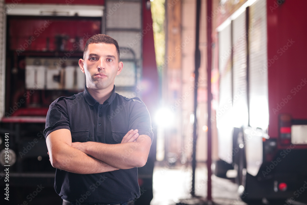 Professional fireman portrait. Firefighter wearing shirt uniform and fire truck in the background. Professional fireman portrait. Firefighter wearing shirt uniform and fire truck in the background.