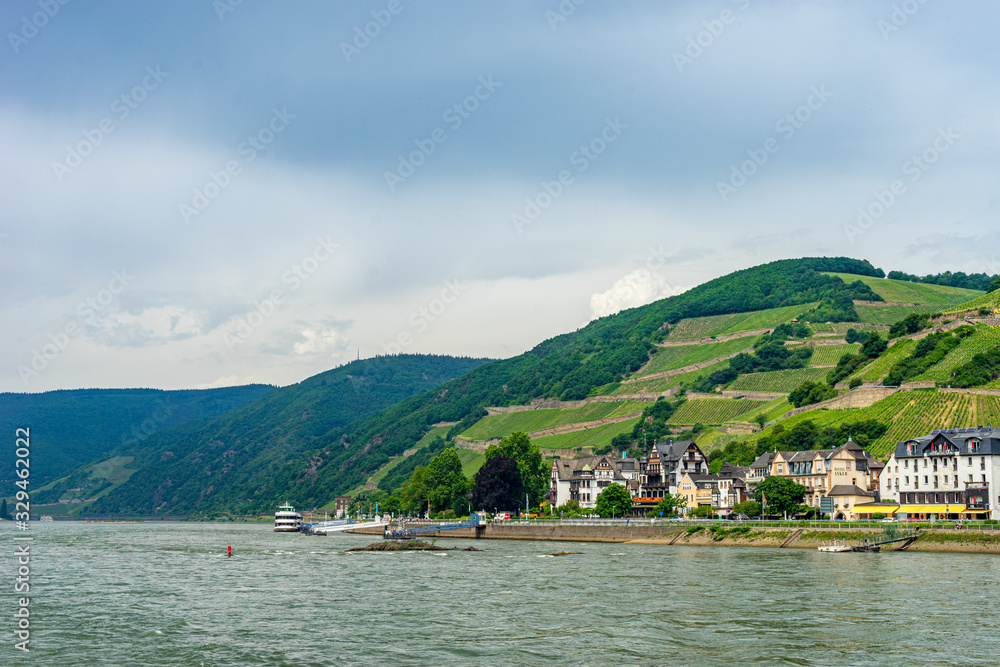 Germany, Rhine Romantic Cruise, a large boat in a body of water with a mountain in the background