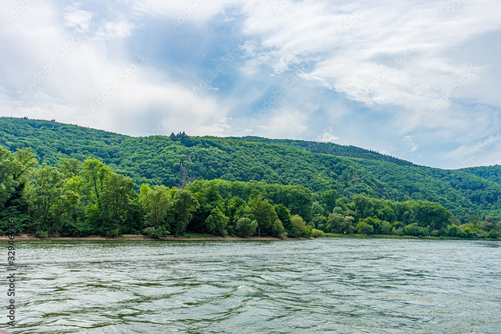 Germany, Rhine Romantic Cruise, a large body of water with a mountain in the background Germany, Rhine Romantic Cruise, a large body of water with a mountain in the background