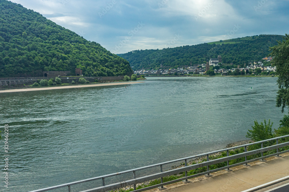 Germany, Rhine Romantic Cruise, a train traveling down train tracks next to a body of water Germany, Rhine Romantic Cruise, a train traveling down train tracks next to a body of water