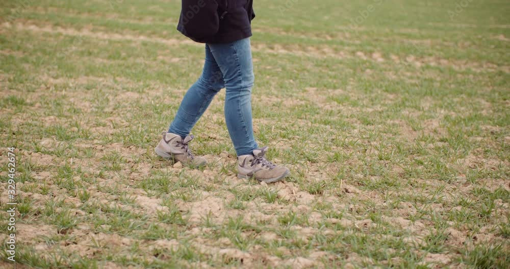 Agriculture - female farmer walking on agricultural field Agriculture - female farmer walking on agricultural field
