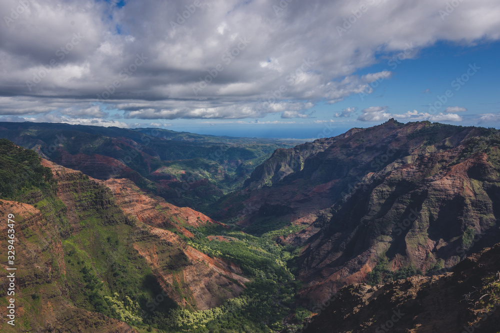 Beautiful Waimea Canyon in Kauai, Hawaii during Cloudy Morning Weather showcasing orange and green canyon landscape Beautiful Waimea Canyon in Kauai, Hawaii during Cloudy Morning Weather showcasing orange and green canyon landscape