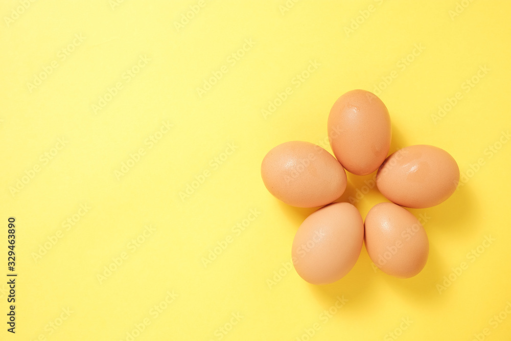 黄色い背景に五個花形に並んだ卵
