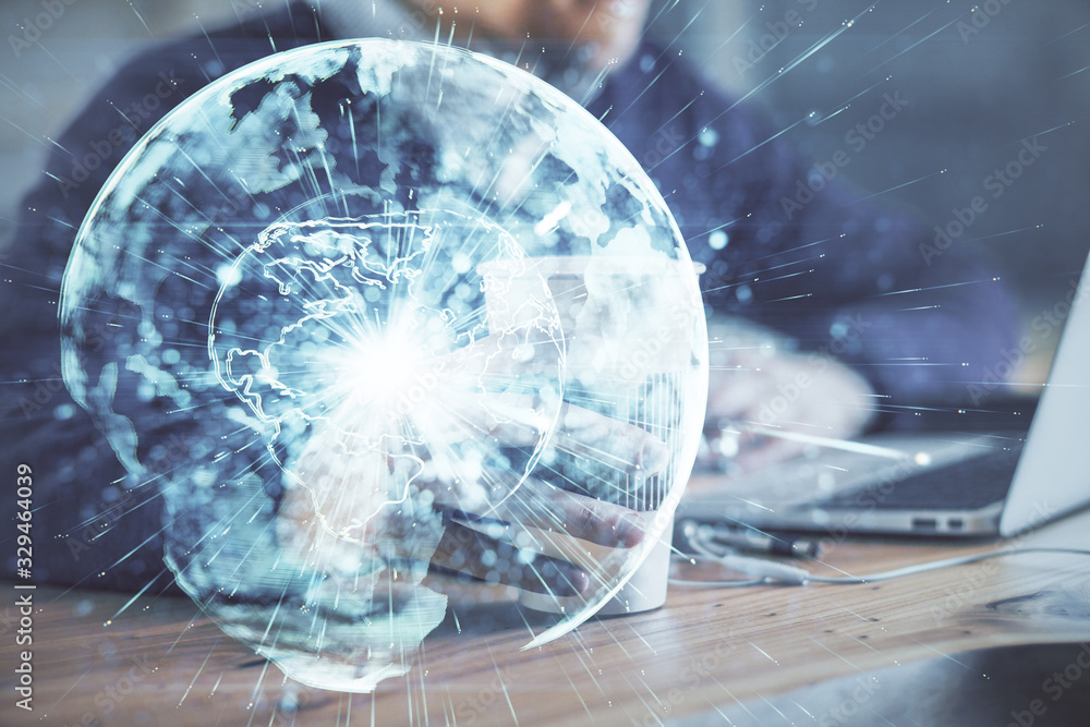 Obraz premium Double exposure of businessman working on laptop on background. International business hologram in front. Concept of success.