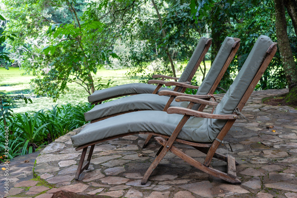Three cozy sun loungers on the tropical garden terrace. Tanzania, Africa, close up