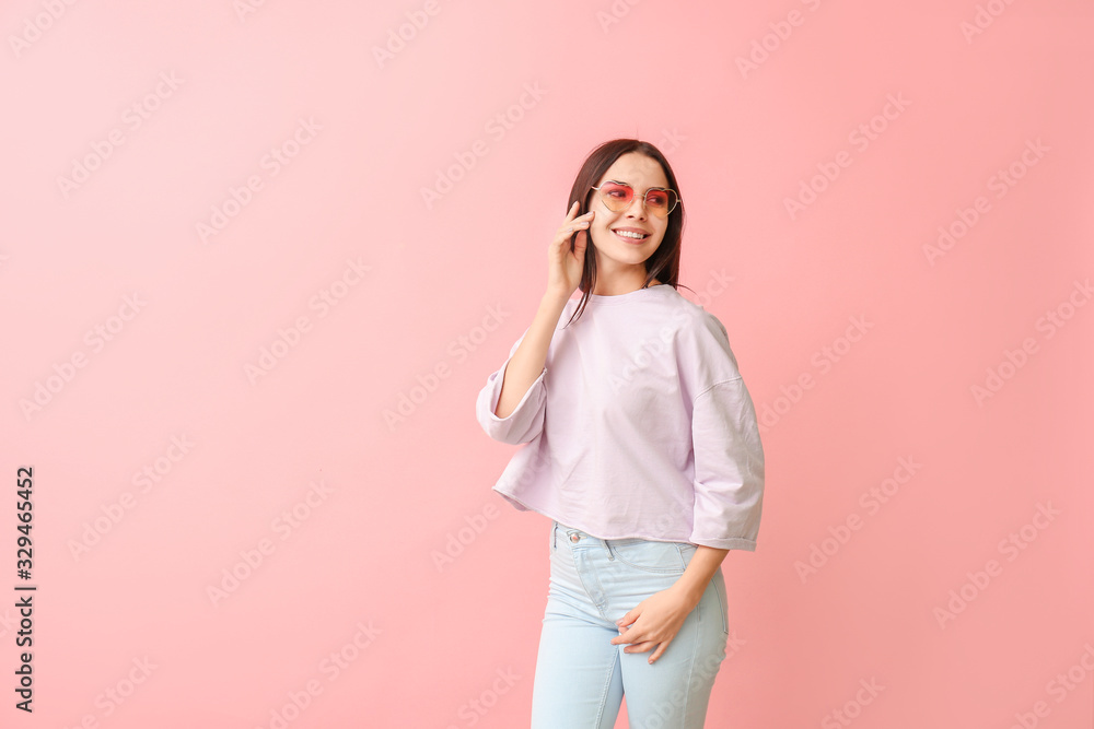 Young woman with stylish sunglasses on color background Young woman with stylish sunglasses on color background