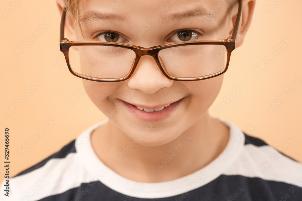 Cute little boy with eyeglasses on color background, closeup