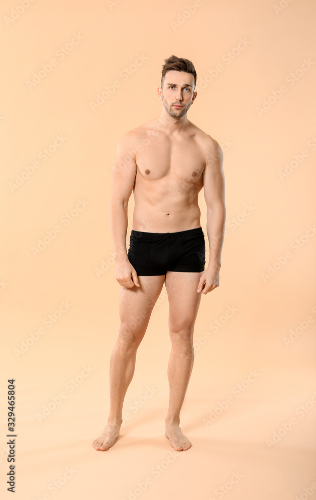 Fototapeta premium Handsome man in underwear on color background