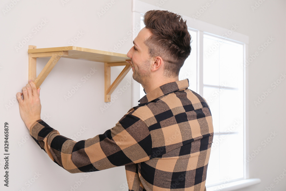 Young man assembling furniture at home