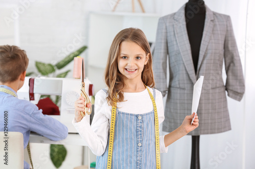 Cute little tailor in atelier