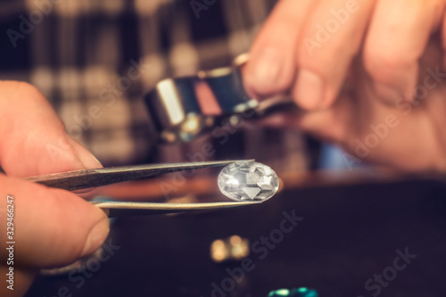 Jeweler examining gemstone in workshop, closeup