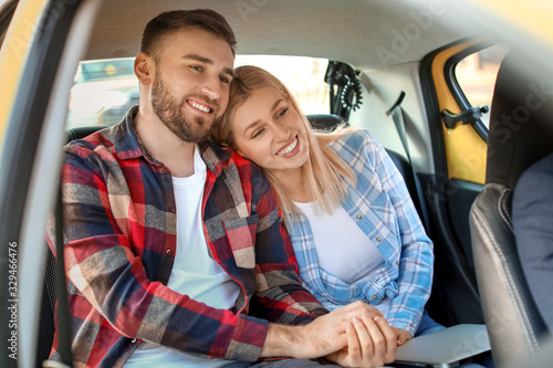 Portrait of young couple sitting in taxi © Pixel-Shot