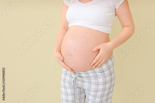 Beautiful pregnant woman on color background © Pixel-Shot