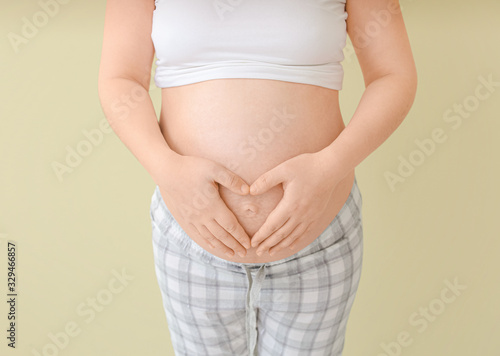 Beautiful pregnant woman on color background © Pixel-Shot