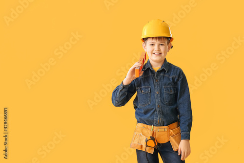 Cute little builder on color background