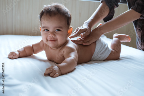 Photography prone baby happy is smile his back by his mother while lying in the bedroom