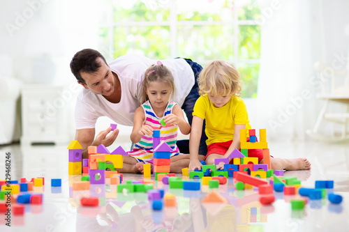 Kids play with toy blocks. Family at home.