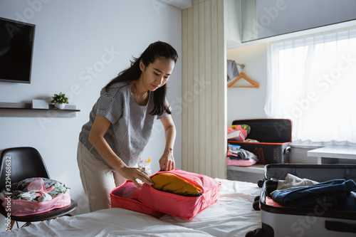 Asian mother prepares clothes and bags to be taken on vacation trips
