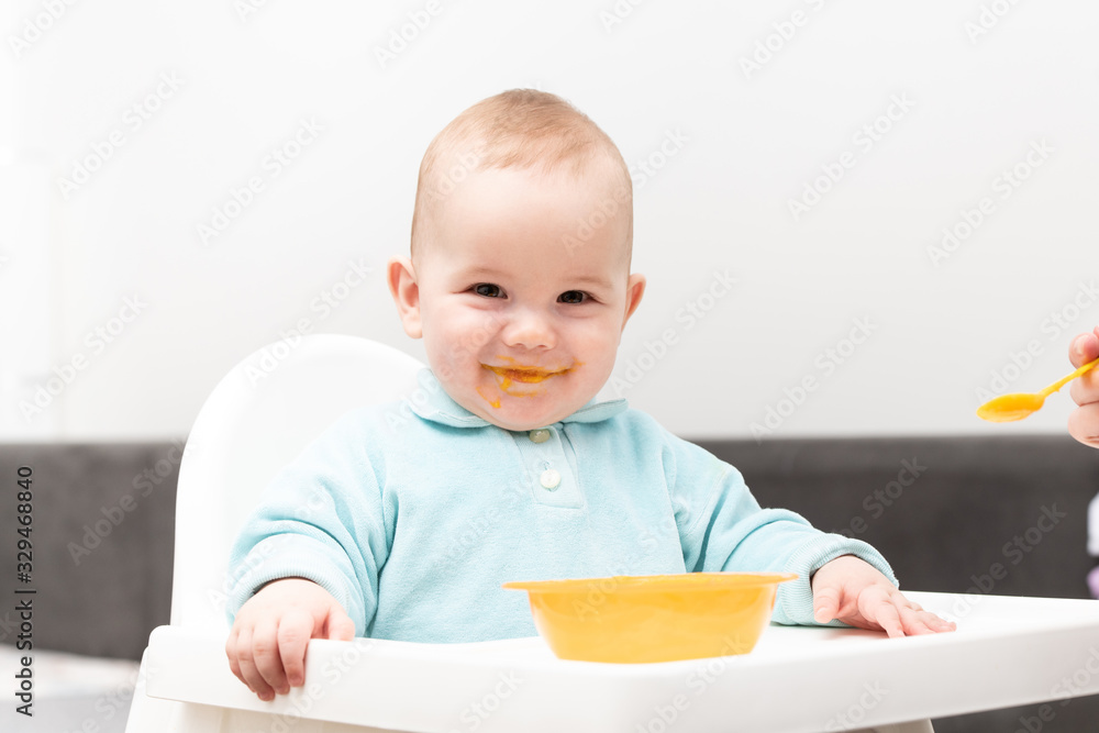 Mom Feeds Baby With Fruit Puree At Home Mom Feeds Baby With Fruit Puree At Home