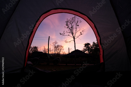 Beautiful Sunrise Morning from iNside of Tent. Camping with SUV Car in Front and Forrest.