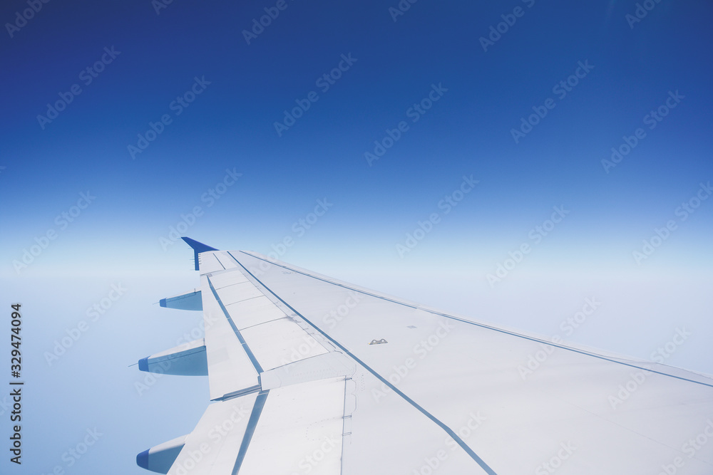 Airplane wing on the sky looking through the airplane window. Airplane wing on the sky looking through the airplane window.