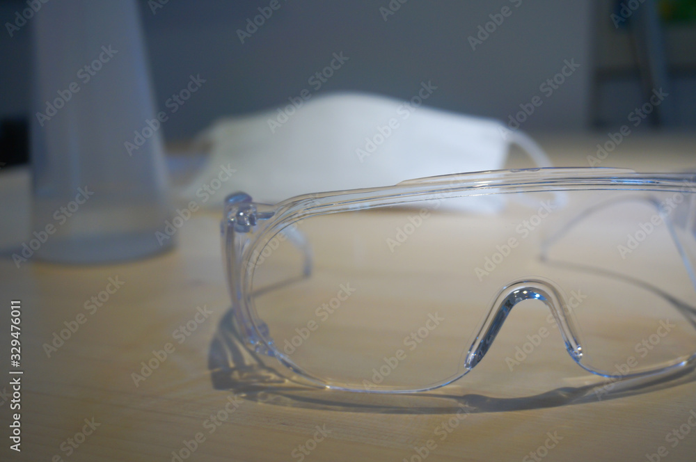 Virus protection equipment sensitizer sprayer respiratory mask and glasses on the table Virus protection equipment sensitizer sprayer respiratory mask and glasses on the table